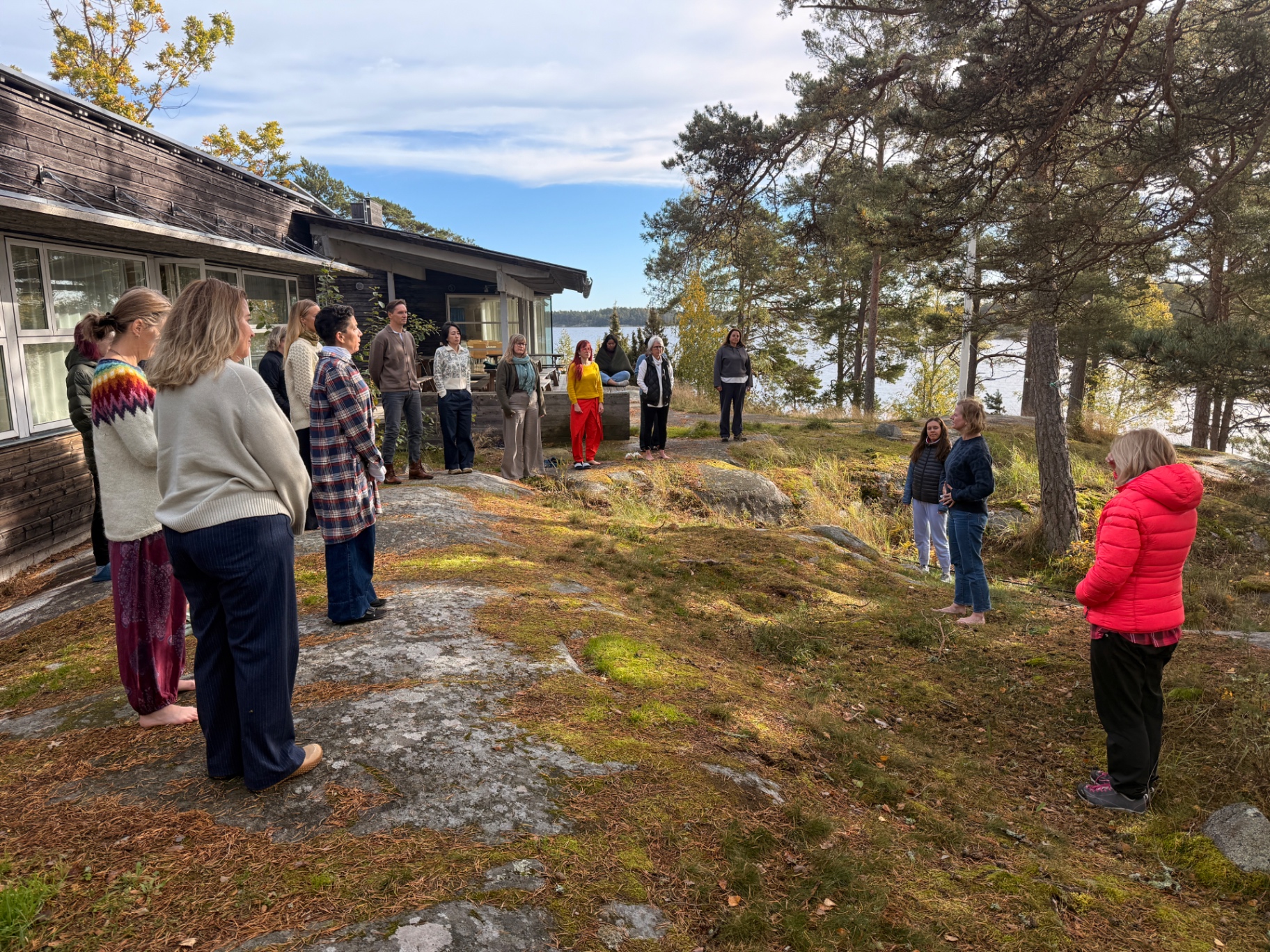 Participants standing in a circle on the granite and grass of Ekskäret Island