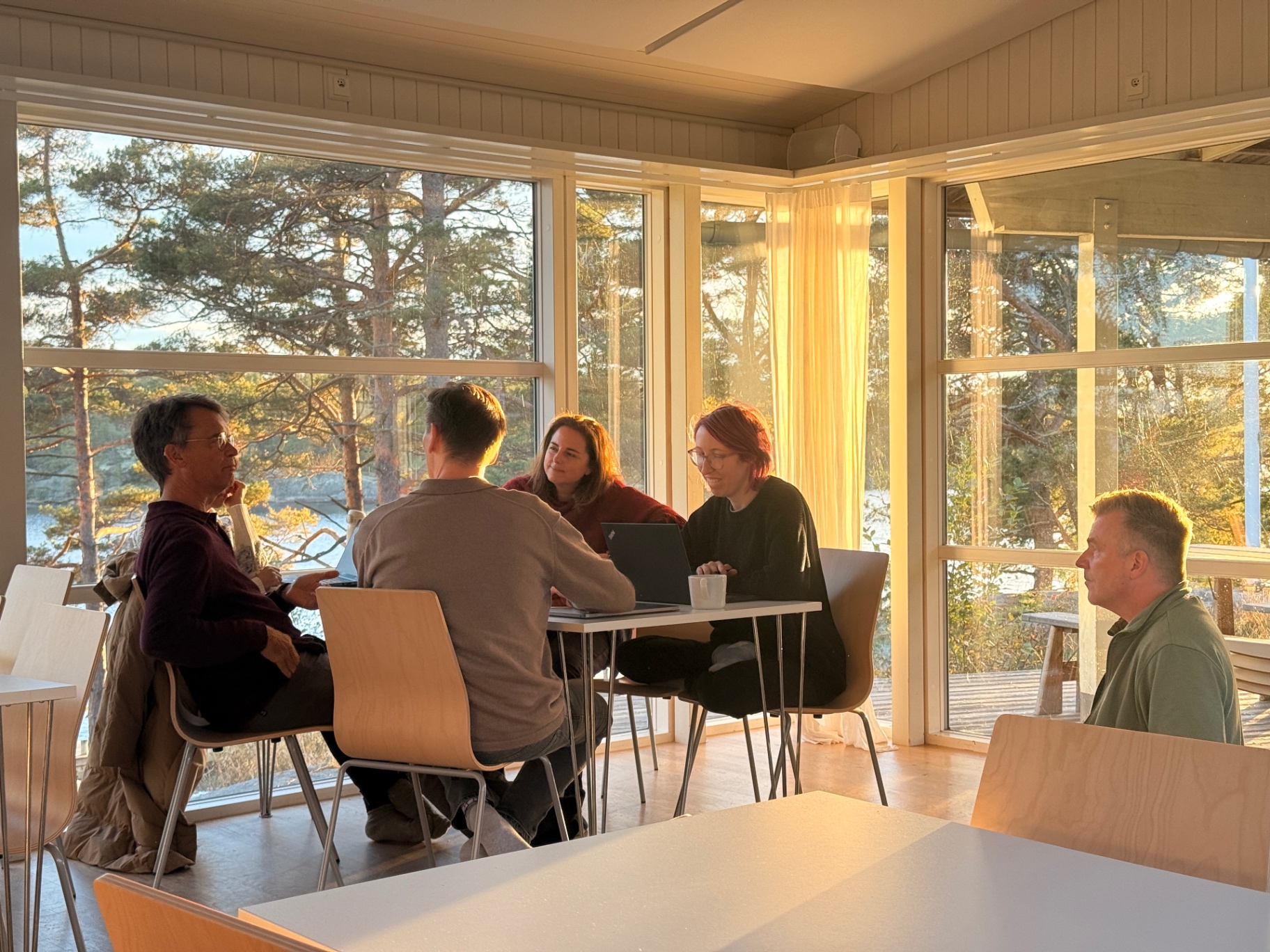 Golden evening light through the tall windows of a common room on Ekskäret Island